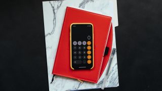 赤い手帳の上に置いてあるスマートフォン