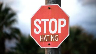 STOP HATINGと書かれた赤い看板